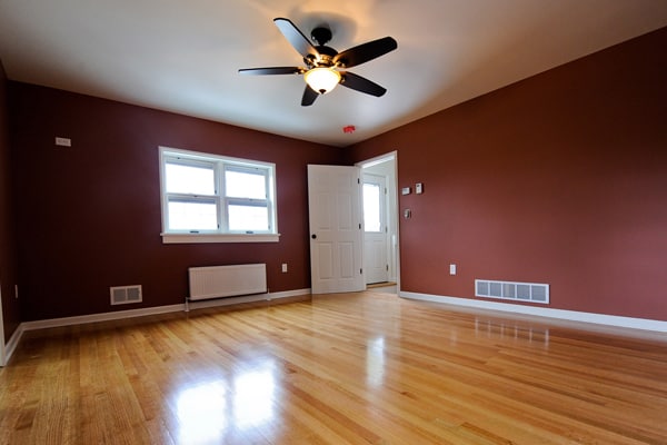 Newly renovated room with red walls and light wood floors